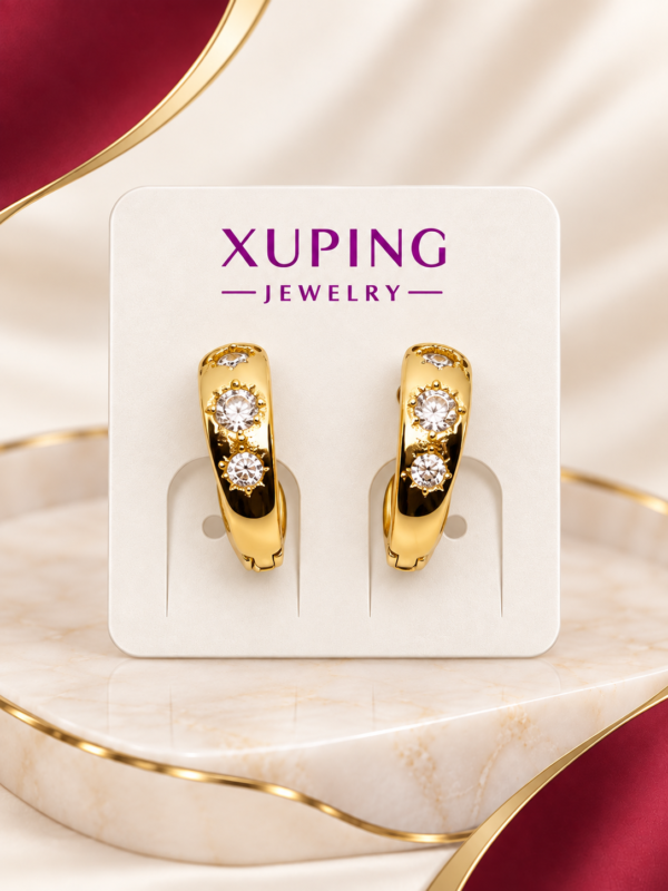 Aretes dorados con diseño de corazón y detalles de piedras